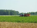 Tractor working in potato field, Lithuania Royalty Free Stock Photo