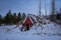 A red traditional icelandic turf cellar in a winter forest, Reykjavik, Iceland.