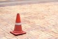 Red traffic cone on tiled rock pavement