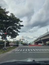 Red Traffic Light Near Zebra Cross beside Flyover aslo baricade and Cloudly Weather at noon