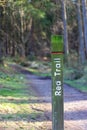 Red trail signpost next to path in Tyrebagger forest Royalty Free Stock Photo