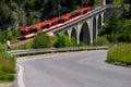 Red train on the circular viaduct bridge in spring in Switzerland Royalty Free Stock Photo