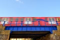 Red train crossing a blue bridge with motion blur Royalty Free Stock Photo