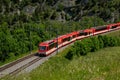 The red train passing on the rail in spring in Switzerland