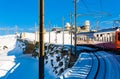 Red train on rack railway approaching station in Swiss Alps on winter day Royalty Free Stock Photo