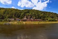 Red train at the Railway station on picturesque bank of the Elbe River of the Elbe river. Small white ferryboat