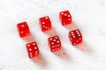 Red translucent craps dices on white board, showing numbers from 1 to 6