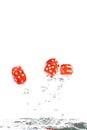 Red transparent dice jumping out of the water