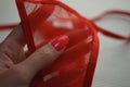 Red transparent panties in a female hand with red manicure