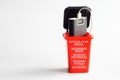 Red trash can with an old discarded power bank - an external battery. Hazardous waste inscription in German, English, Spanish,