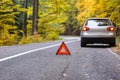 Red triangle of a car on the road.Broken car in forest.damage ca