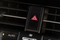 Red triangle hazard light button on car dashboard.