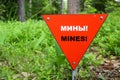 Red triangle mine warning sign in the forest Royalty Free Stock Photo