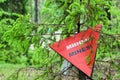 Red triangle mine warning sign in the forest Royalty Free Stock Photo
