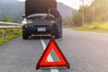 Red triangle sign on road for warning have car with breakdown open car hood and man fixing a car Royalty Free Stock Photo