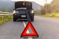 Red triangle sign on road for warning have car with breakdown open car hood and man fixing a car Royalty Free Stock Photo