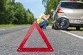 Red triangle sign and Sad man after car breakdown Royalty Free Stock Photo