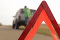 Red triangle of a stopped car on the road. An emergency stop sign mounted on the road against the background of stopped car. Royalty Free Stock Photo
