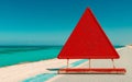 A red triangle warning sign placed on a calm sandy beach with a turquoise sea in the background Royalty Free Stock Photo
