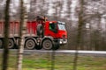 Red truck moving on a highway and in a hurry to deliver goods on time Royalty Free Stock Photo