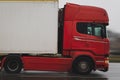 Red truck pulls a semi-trailer in the rain on the road. Close-up, motion blur Royalty Free Stock Photo