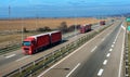 Red Trucks in line on a rural countryside highway Royalty Free Stock Photo