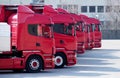 Red trucks lined up in a parking lot of a transport and shipping company, ready to go. Royalty Free Stock Photo