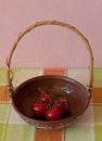 Red Truss Tomatoes In A Bowl On A Colorful Checked Tablecloth Against A Pink Wall