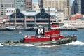 Red tugboat passes South Street Seaport, New York