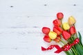 Red tulips bouquet decorated with ribbon on white wooden background. Copy space, top view. Mothers Day, Birthday, Valentines Day Royalty Free Stock Photo