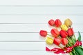 Red tulips bouquet decorated with ribbon on white wooden background. Copy space, top view. Mothers Day, Birthday, Valentines Day Royalty Free Stock Photo