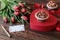 Red tulips bouquet and red heart gift box with chocolate cupcake decorated with sweet hearts on the box, empty card, pen, small Royalty Free Stock Photo