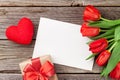 Red tulips, gift box and Valentine`s day greeting card Royalty Free Stock Photo