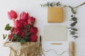 Red tulips with greeting card, gift, pencil, scissors and twine on rustic white wood flat lay Royalty Free Stock Photo