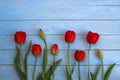 Red tulips on a wooden background with a place for inscription