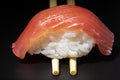 Red tuna nigiri on a background caught with chopsticks