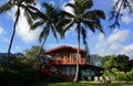 Red Two Story Beach House with tall coconut trees