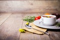 A fragrant red borscht in a white plate with a lots of vegetables on wooden background. Food concept.