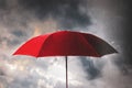 Red umbrella against the storm,sky background and black cloud group and rain, preventing rain and wind hazards,saving planning, Royalty Free Stock Photo