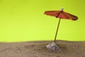 Red umbrella beach attached with stones and beach sand Royalty Free Stock Photo