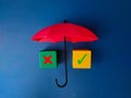 Red umbrella and colored cube with sign wrong and right on blue background. Royalty Free Stock Photo