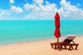 Red umbrella, deck chair, solar parasol, sun lounger, chaise lounge, sun bed, tropical island sea beach, summer holidays, vacation Royalty Free Stock Photo