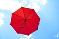 Red umbrella flying on blue sky