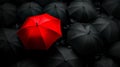 A red umbrella sitting in the middle of a group of black umbrellas Royalty Free Stock Photo