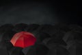 Red umbrella stand out from group of many black umbrellas, Royalty Free Stock Photo