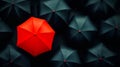 A red umbrella surrounded by black umbrellas in the rain Royalty Free Stock Photo