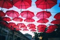 Red umbrellas over street in european city, urban festive background and texture Royalty Free Stock Photo