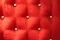 Red upholstery background with gold buttons