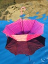 Red upturned umbrella floating on water surface