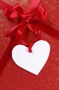 Red valentine gift, white heart shape gift tag or label, copy space, vertical Royalty Free Stock Photo